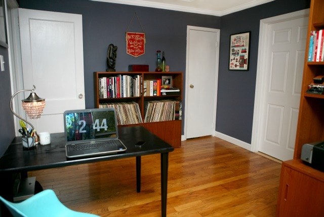 Home office with mid century modern Scandanavian bookcase and laptop on a black desk