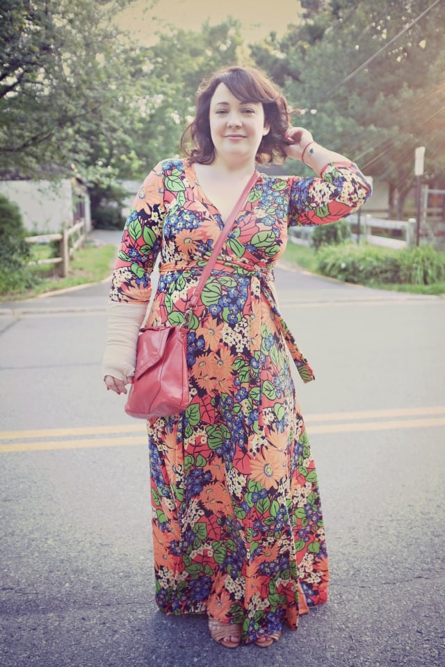 Alison Gary of Wardrobe Oxygen in a floral wrap maxi dress from Etsy and a red leather crossbody from Latico. She has a cast on her right arm 