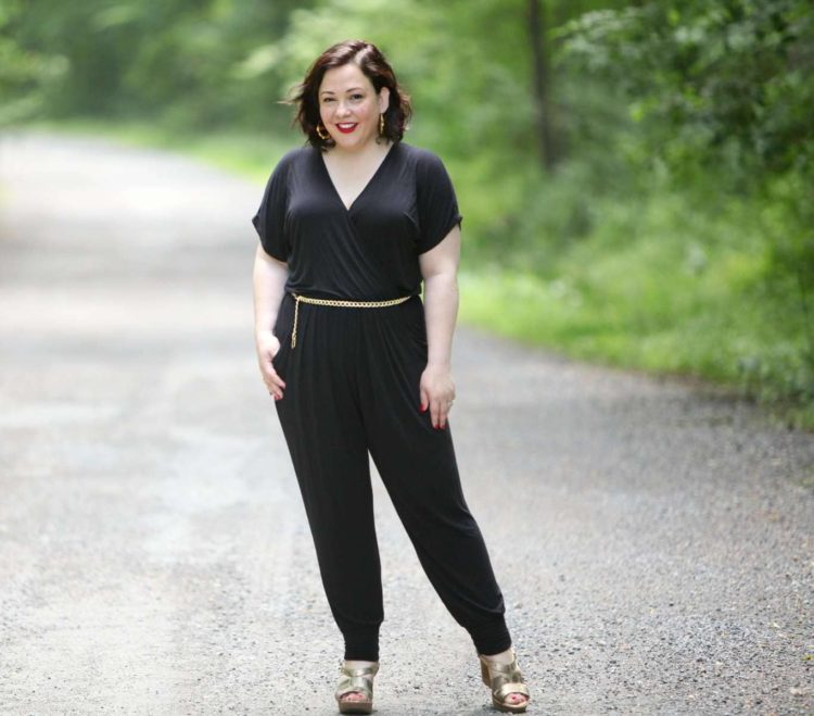 Wardrobe Oxygen wearing a Loveappella jumpsuit, J. Crew Factory denim jacket, and Love,Cortnie clutch bag