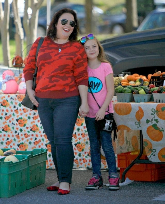 Wardrobe Oxygen in a red camo print cabo sweater, dark jeans, and Rothy's flats