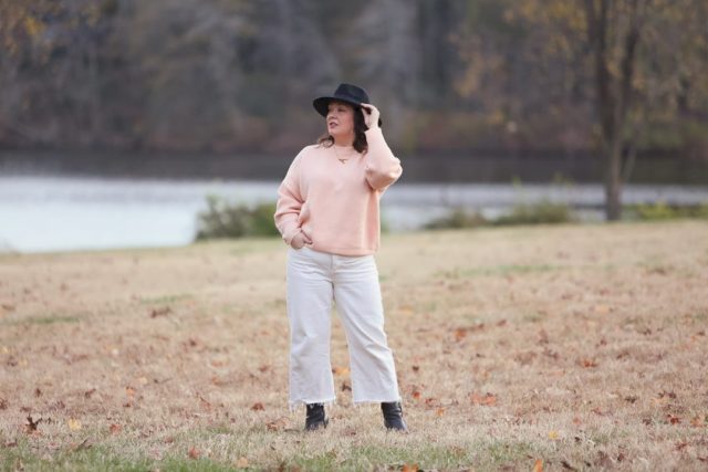 Wardrobe Oxygen in the And Comfort Fika sweater in peach with cream wide leg cropped jeans from Universal Standard, a black felt fedora from Ann Taylor, gold Faye Knocker hoop earrings from Jenny Bird, and black Clarks ankle booties