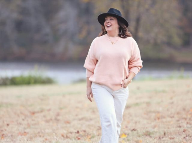 Wardrobe Oxygen in the And Comfort Fika sweater in peach with cream wide leg cropped jeans from Universal Standard, a black felt fedora from Ann Taylor, gold Faye Knocker hoop earrings from Jenny Bird, and black Clarks ankle booties