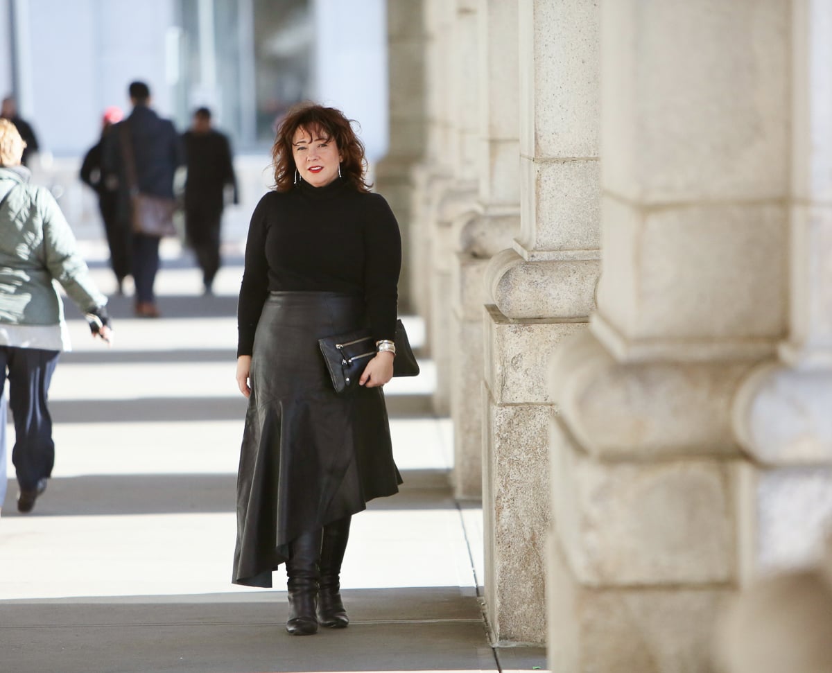 Wardrobe Oxygen in a black cashmere turtleneck, black leather asymmetrical skirt from Topshop, and silver Jenny Bird Trust Hoops with black knee-high wide calf heeled boots #over40fashion #40plusstyle #petitefashionblogger