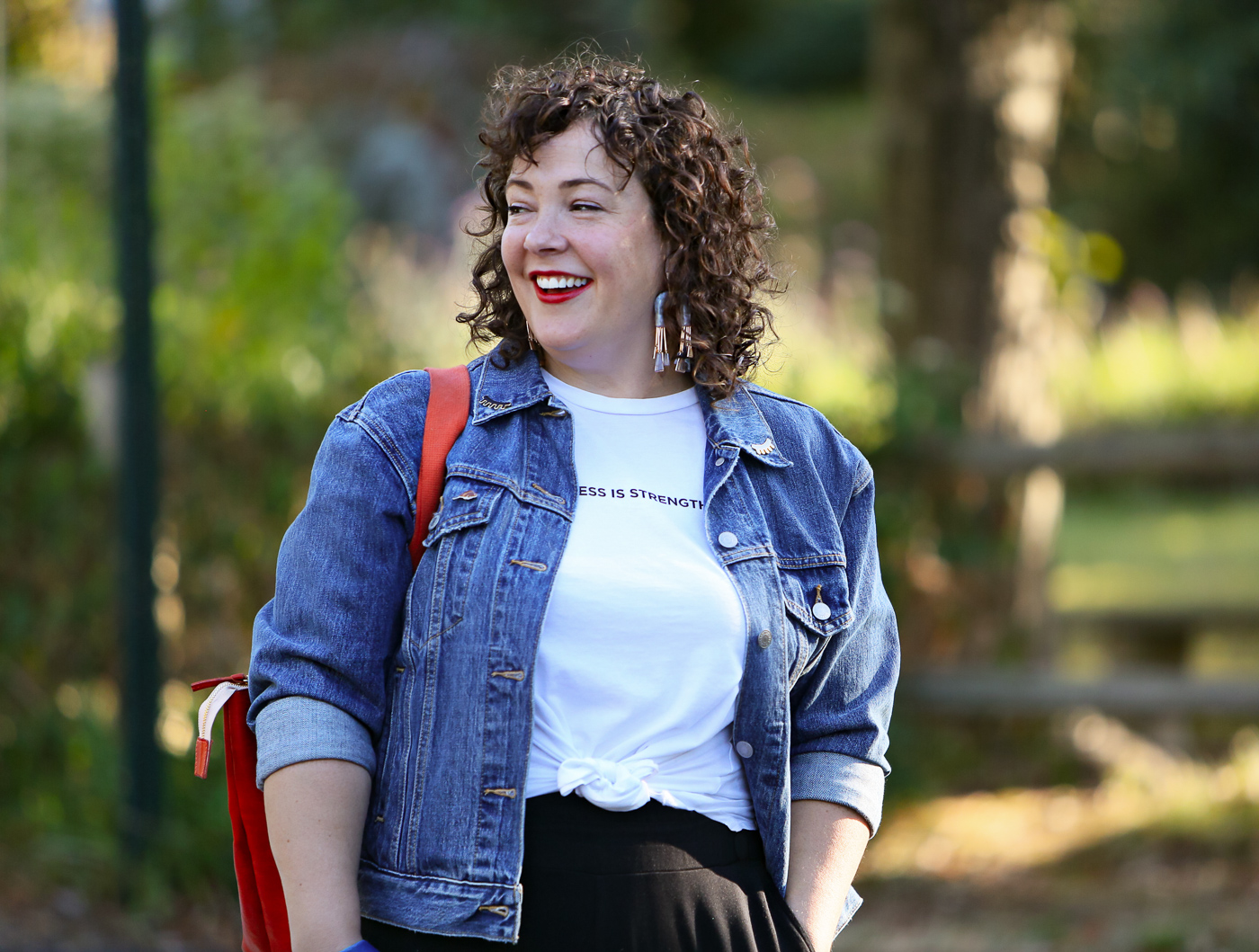 woman in denim jacket smiling and looking to her right