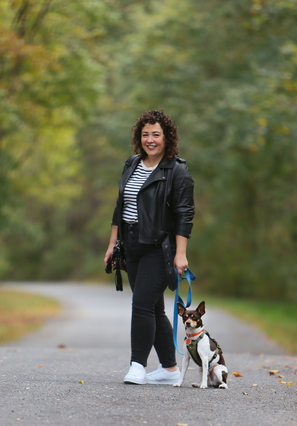 Alison Gary in a Universal Standard leather moto jacket, Everlane jeans, and an ALLSAINTS snakeskin print purse