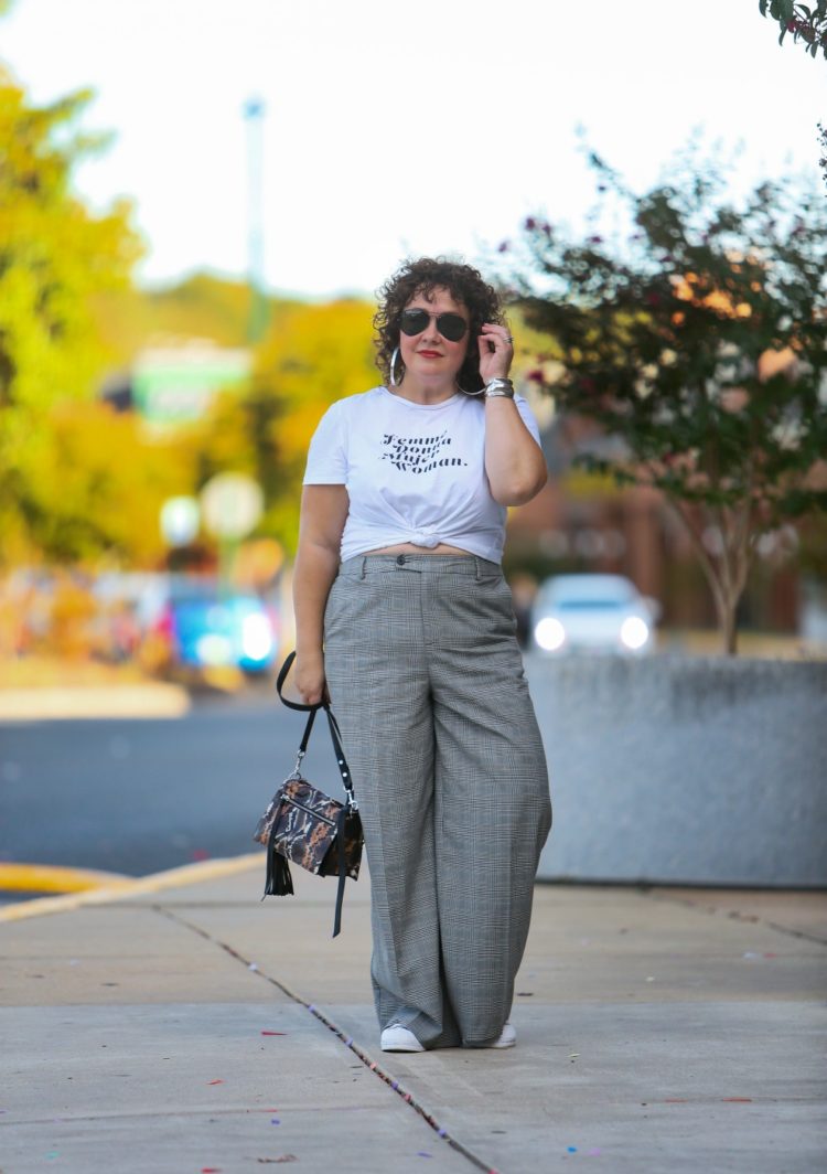 woman in wide leg gray pants and a white t-shirt knotted at her waist