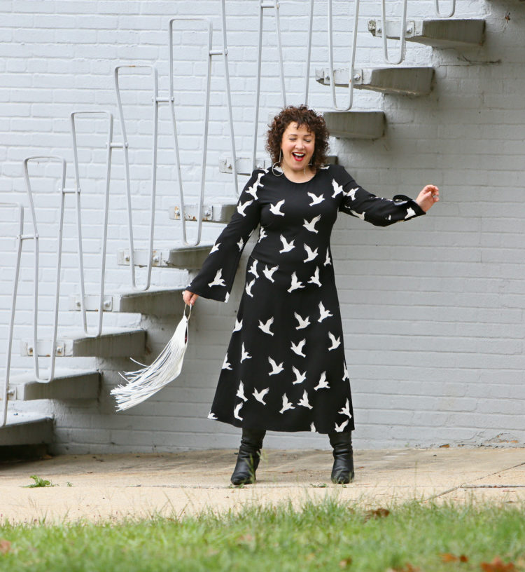 Black Stine Goya dress with white bird print styled with Kara Bags fringed purse and black heeled knee high boots