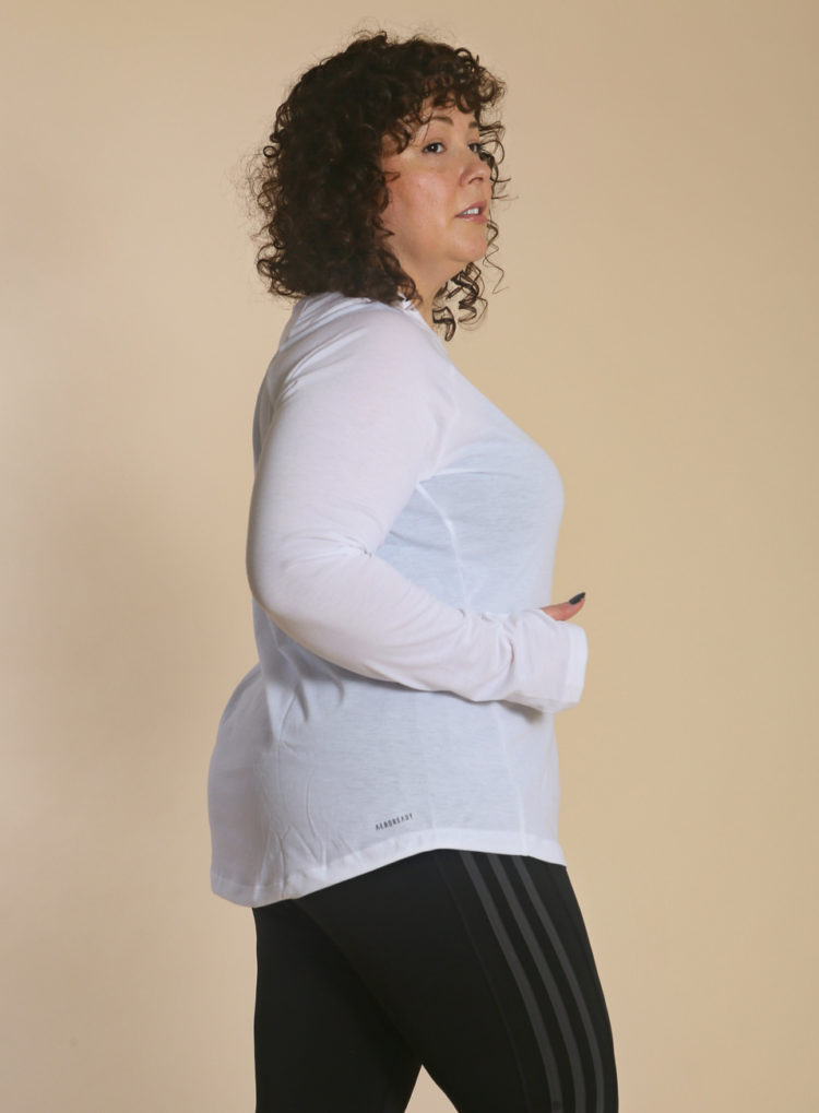 woman in white long sleeved tee from the universal standard and adidas collection