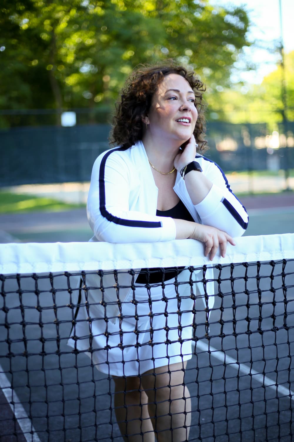 Alison in a white bomber jacket with a black stripe down the arm and a matching skort. Both are from Talbots.