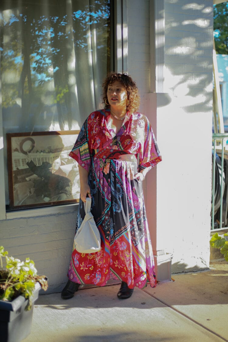 Wardrobe Oxygen in a printed maxi dress against a white brick wall wearing Ros Hommerson Maryland wide calf boots