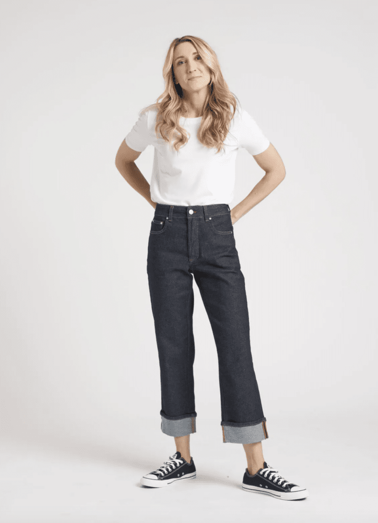 Woman in a white t-shirt wearing dark wash widely cuffed jeans from Universal Standard