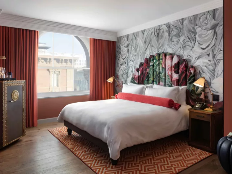 A photo of a king bedroom at the Hotel Riggs Washington DC featuring a view of the city and the hotel's iconic bank safe minibar