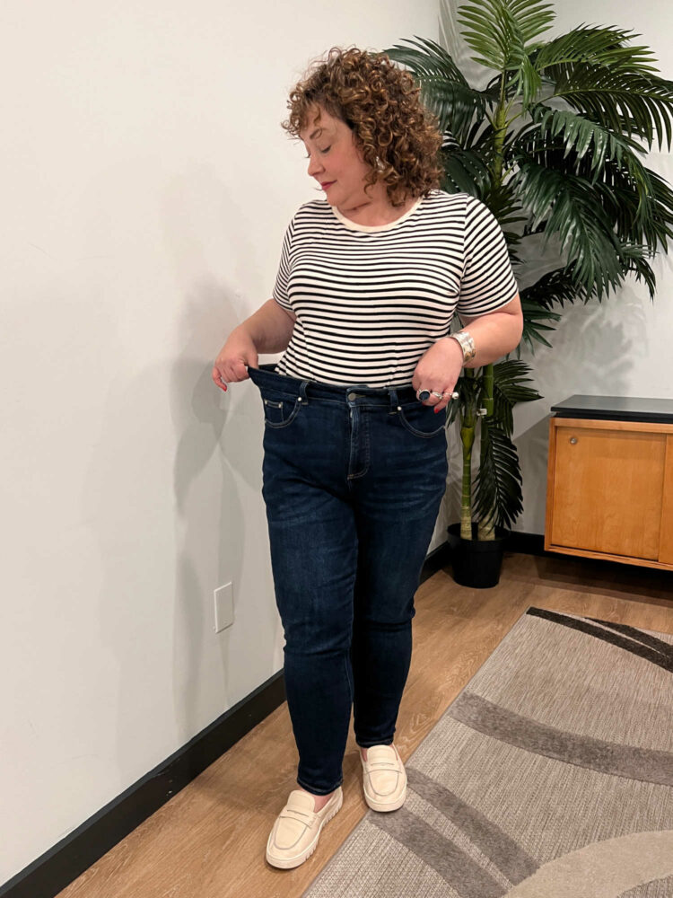 Alison wearing a striped t-shirt tucked into Universal Standard Joni jeans in a dark wash.