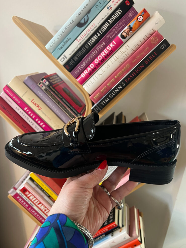 side view of the anne klein korrie loafer in black patent with gold hardware