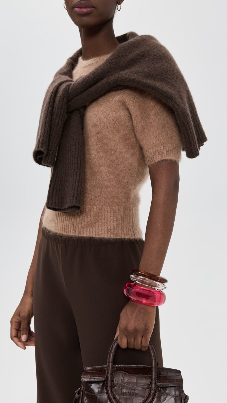 Why I'm Embracing the Bangle Bracelet Trend 5 a model wearing three bangles in pink, clear, and brown